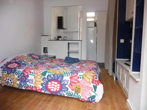 里昂Appart-Hotel T1 Lyon8 proche hopitaux的一间卧室配有一张带彩色毯子的床