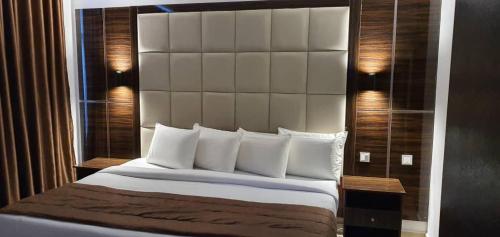 伊凯贾Presken Hotel at International Airport Road的一间卧室配有一张大床和大床头板