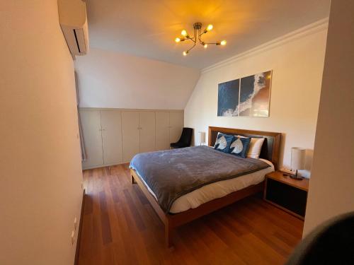 埃斯托利尔Heart of Ocean Dulpex Estoril的一间卧室配有一张床和一个吊灯