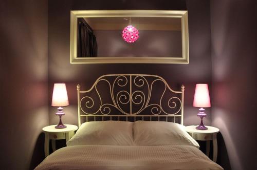 华沙Chmielna Guest House的一间卧室配有一张带两盏灯和镜子的床