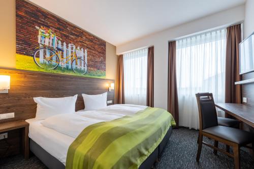 明斯特Trip Inn Hotel Münster City的配有一张床和一张书桌的酒店客房