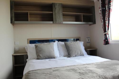 佩伦波斯Perran Sands Perranporth的一间卧室配有带白色床单和枕头的床。