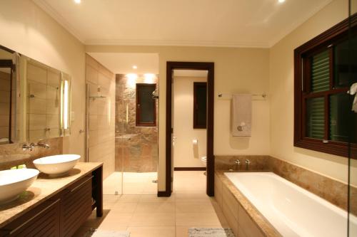 伊甸岛Eden Island Maison 78 (Private Pool)的浴室配有2个盥洗盆、浴缸和淋浴。