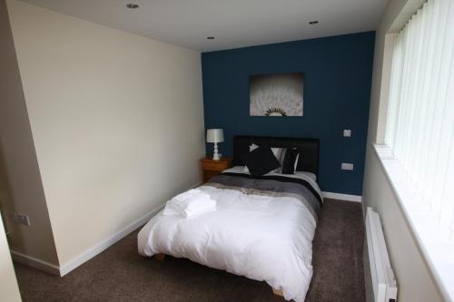 梅里登布罗德韦尔旅馆的一间卧室配有一张蓝色墙壁的床