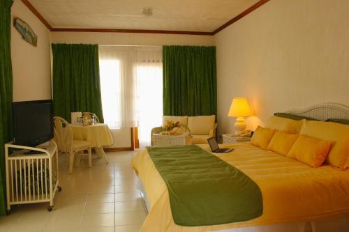 总督港尤妮克乡村酒店的一间卧室配有一张带绿色窗帘的大床
