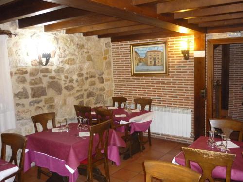 桑托多明戈德锡洛斯Hotel Rural Villa de Silos的餐厅配有桌椅和紫色桌布