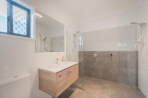 洛坎普顿Jardine Court Appartments的一间带水槽、淋浴和卫生间的浴室
