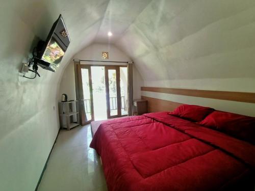 巴图Pagupon Camp Syariah的一间卧室设有红色的床和窗户。
