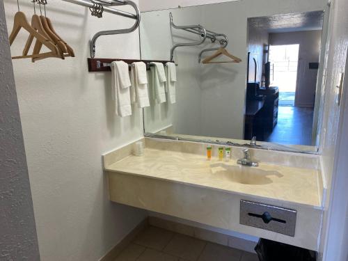 蒙哥马利Luxury Inn的浴室配有带镜子的盥洗盆和毛巾