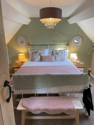 布里奇诺斯Bell Cottage right in the heart of Bridgnorth的一间卧室配有一张大床和一个吊灯。