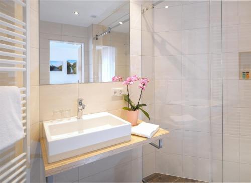 KruchtenLandgasthaus Hoffmann的白色的浴室设有水槽和淋浴。