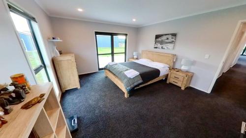 AtiamuriFull holiday home to yourself, up to 21 guests的一间卧室配有一张床、一张书桌和一个窗户。
