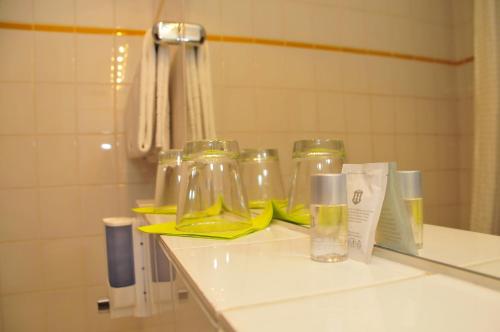 弗里德贝格布鲁诺酒店的浴室柜台上装有三瓶玻璃瓶