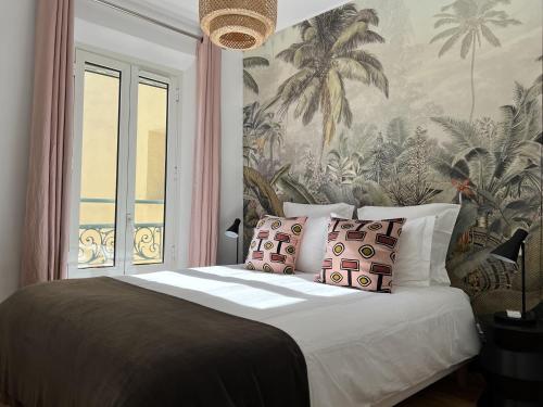戛纳LE BAIN DE SOLEIL luxury 2 bedrooms Cannes centre的一间卧室配有一张带热带壁纸的大床