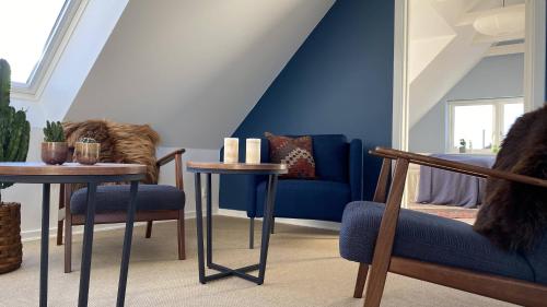 锡尔克堡Villa Søholt - Silkeborg Bed and Breakfast的一间设有蓝色墙壁和桌椅的房间