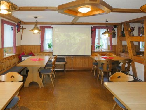 西蒙斯瓦尔德Holiday Home Hexenstüble by Interhome的配有桌椅和投影屏幕的教室