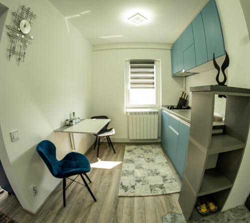 PetrilaStudio Lupul的小厨房配有桌子和蓝椅