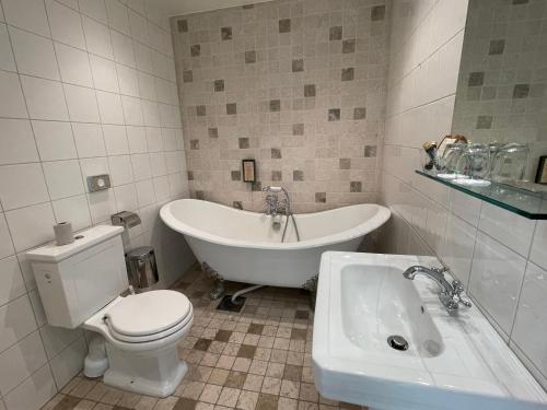 瓦克斯霍尔姆瓦克斯赫尔姆酒店的带浴缸、卫生间和盥洗盆的浴室