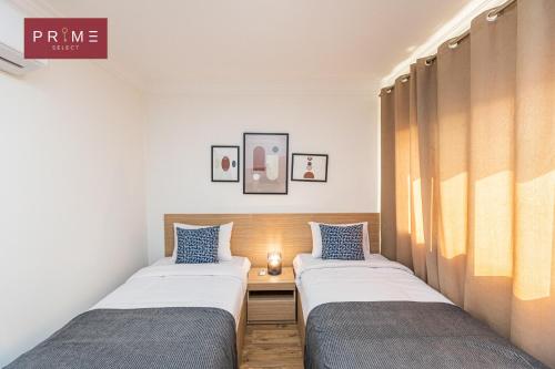 开罗Prime Select Sheraton的小客房内的两张床,配有蓝色枕头