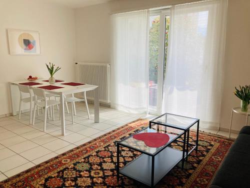 洛迦诺Appartamento con giardino al Melograno的一间带桌子的客厅和一间餐厅