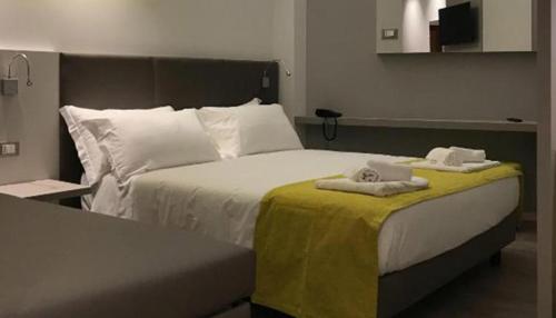 里米尼蒙马特酒店的一间卧室配有一张床,上面有两条毛巾