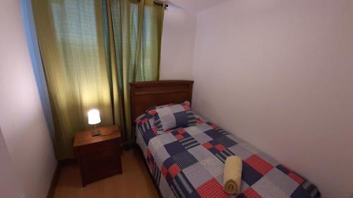 兰卡瓜Vista Apartments - Aire Acondicionado y Estacionamiento的一间小卧室,配有一张床和一张桌子上的台灯