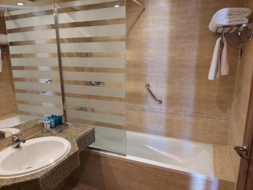 沙姆沙伊赫Sunrise Remal Resort的带淋浴、盥洗盆和浴缸的浴室
