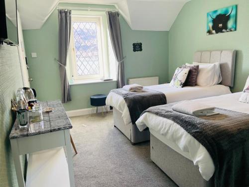 威廉堡Whinburn Guest House的小房间设有两张床和窗户