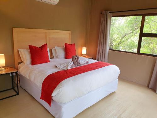 侯斯普瑞特Kingfisher Creek Safari Lodge的一间卧室配有一张大床,床上放着一只狗