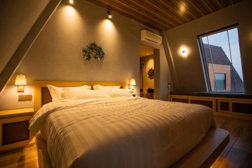 One of A Kind Resort @Trikora Beach - Bintan的一间卧室设有一张大床和一个窗户。