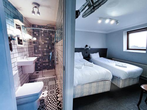 伦敦广场酒店的酒店客房设有两张床和淋浴。