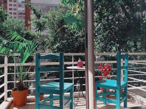 布宜诺斯艾利斯Palermo Deluxe Apartment的阳台桌子旁的两把蓝色椅子