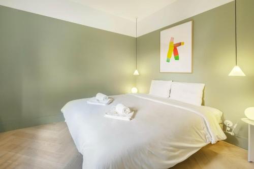 卡斯卡伊斯Jardim Suites by Olala Homes的卧室配有一张白色大床和两条毛巾