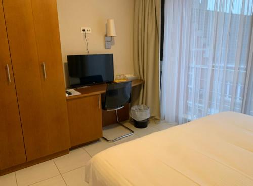 尼诺纲德克罗尼酒店的酒店客房配有一张床和一张书桌及一台电视