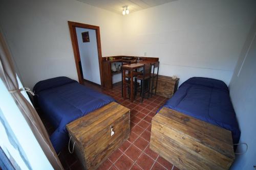厄尔查尔坦Magna的客房设有两张床、一张桌子和一张桌子。