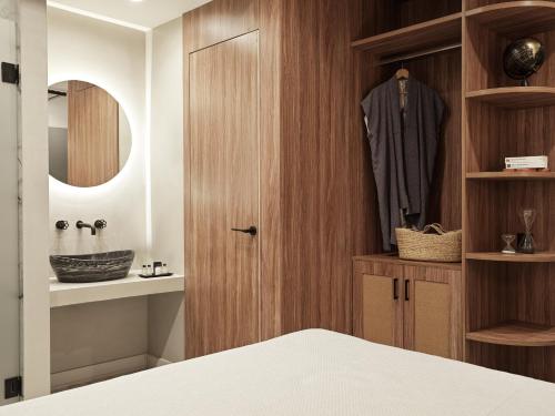 雅典Athens City View Urban Suites的一间卧室配有带浴袍的木制衣柜