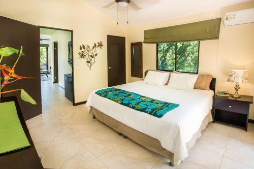 奎波斯城Tropical Paradise Villa - Beautiful Pool, Surrounded by Nature and Wildlife!的一间卧室设有一张大床和一个大窗户