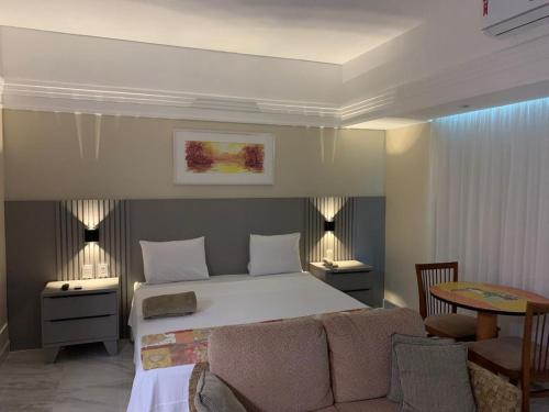 马瑙斯Flat Tropical的卧室配有一张床和一张桌子及椅子