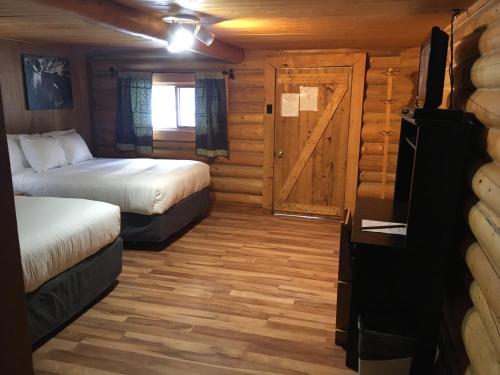 Muncho Lake杜布勒G服务酒店的一间设有两张床的房间和一扇门的小屋
