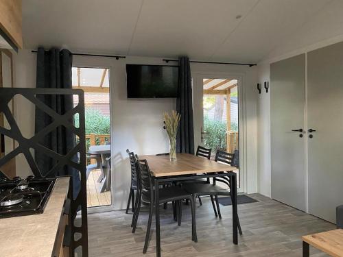 圣西普里安MOBIL-HOME NEUF 2021 3CH 34 M2的一间带木桌和椅子的用餐室