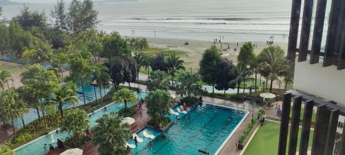 关丹Timurbay Seaview & Poolview by Zuhayr Suite的海滩上游泳池的空中景致