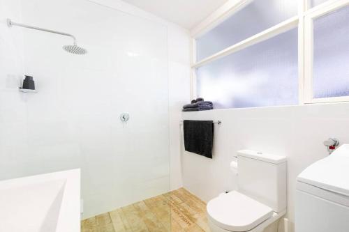 BurnsideModern Stylish Self-contained Studio Apartment的白色的浴室设有卫生间和窗户。