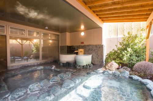 山中湖村富士山中湖森普莱斯酒店的庭院内带两个浴缸的游泳池