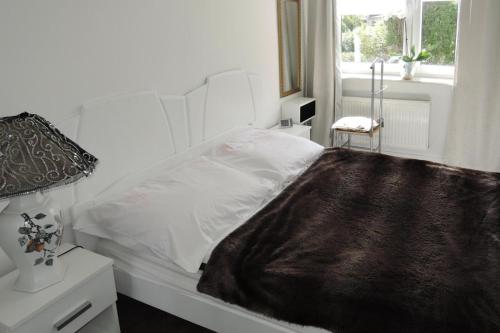 斯维诺乌伊希切Holiday flat, Swinoujscie的窗户客房内的一张白色床