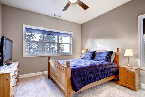 西优胜美地Kildrummy Lodge的一间卧室设有一张床、一台电视和一个窗口。