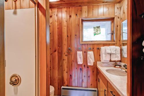 西优胜美地Stoneoaks的浴室设有木墙、水槽和镜子