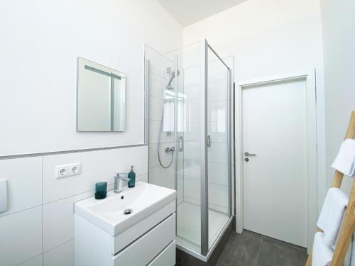 美茵河畔哈瑙Best Boarding House的白色的浴室设有水槽和淋浴。