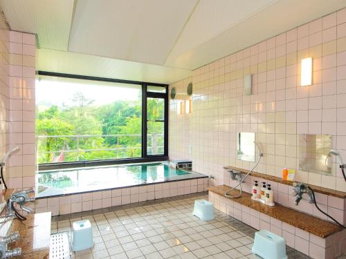 Kami玉莫诺温泉日式旅馆的一个带游泳池和窗户的大浴室