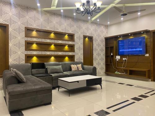 拉瓦尔品第Luxury Guest House in Bahria Town的带沙发和电视的客厅