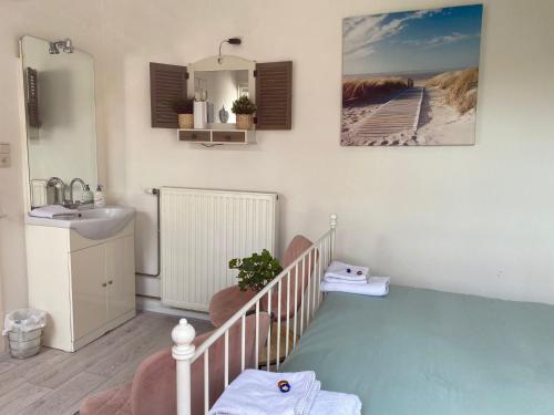 海边的艾格蒙特B&B de Zandtaart的浴室设有婴儿床、水槽和镜子
